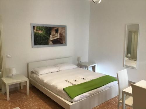 ein Schlafzimmer mit einem Bett mit einer grünen Decke darauf in der Unterkunft A due passi da Giulietta-Casa Capuleti in Verona