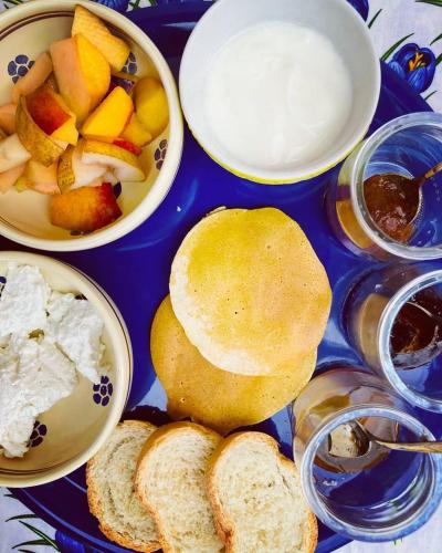 a blue tray topped with plates of food with bread and fruit at Sorelle Biologiche in Monte Castello di Vibio