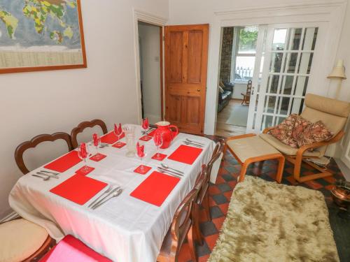 a dining room with a white table with red napkins at Hawthorn House in Pembroke