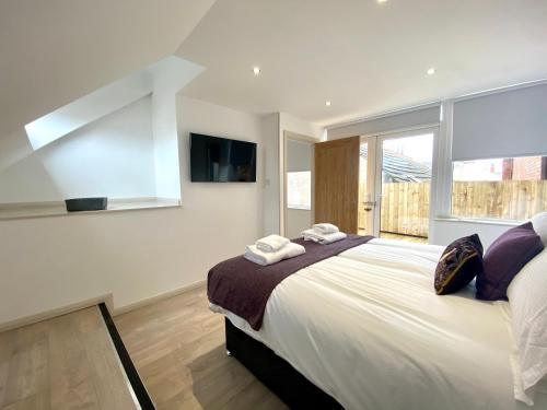 a bedroom with a large bed and a large window at Princess Theatre Beach View Apartments in Blackpool