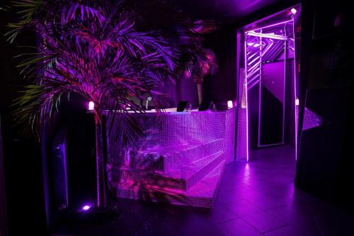 a purple room with a table and a palm tree at Excentric Studio 2 in Braşov