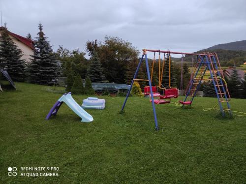 a group of playground equipment in a yard at Baranie Wzgórze Ustroń Basen Sauna Plac Zabaw in Cisownica