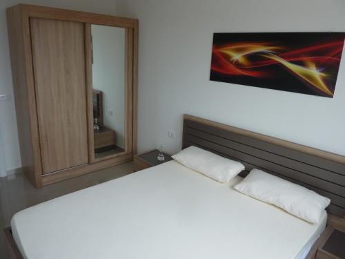 Cama blanca en habitación con espejo en Blue View, en Bar