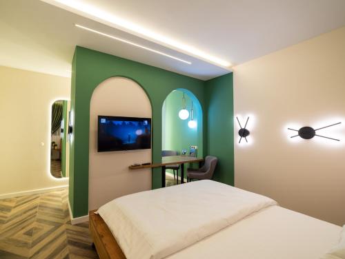 um quarto com uma parede verde com uma cama e uma mesa em Art’partment em Brasov