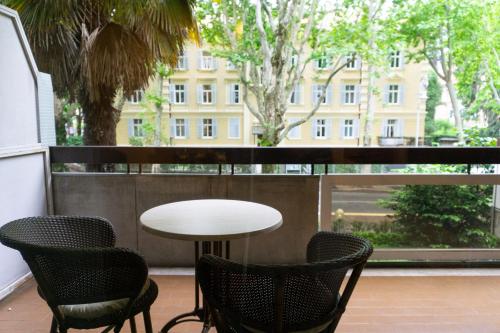 stół i krzesła na balkonie z widokiem na budynek w obiekcie Meran/o Centro Guest House w Meranie