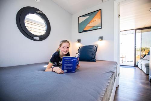 OphovenにあるOtter Easy Houseboats, Comfortklasse M huisboot Hausbootのラップトップを持って寝た女