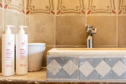 two bottles ofodorizers sitting on a counter next to a sink at Nido di Modica con vista in Modica