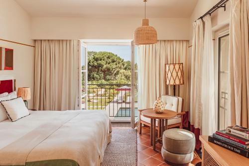 a hotel room with a bed and a balcony at Hotel Lou Pinet in Saint-Tropez