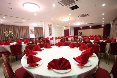 a dining room table filled with red velvet chairs at Cairnhill Hotel Kuala Lumpur in Kuala Lumpur