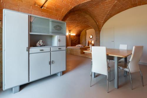 a kitchen and dining room with a table and a bed at Tognazzi Casa Vacanze - La Collina di San Gimignano in San Gimignano