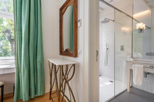 a bathroom with a shower and a sink and a mirror at Santiago de Alfama - Boutique Hotel in Lisbon