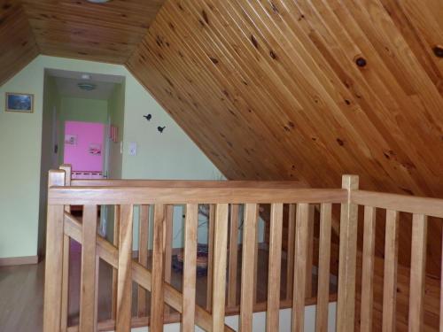 a wooden staircase in a room with a wooden ceiling at Gîte Clévacances dans le Finistère in Scrignac