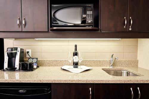 a kitchen counter with a sink and a microwave at RiverRock Inn in Rockland