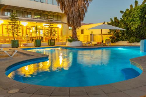 a swimming pool in front of a hotel at Hotel Chagall in Copiapó