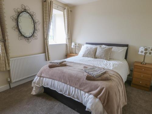a bedroom with a bed with two towels on it at Hill Top Cottage in Keighley