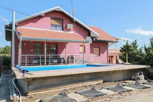 a pink house with a pool in front of it at Vila Viktori in Pirot