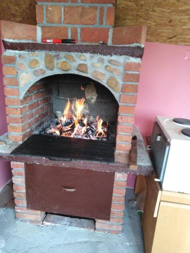 a brick oven with a fire in it at Vila Viktori in Pirot