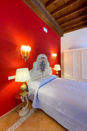 a bedroom with a white bed with a red wall at Princess Art Hotel in Ferrara