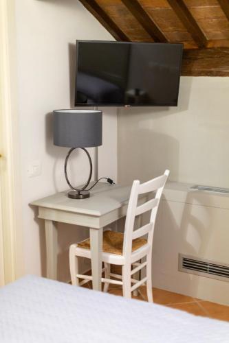 a bedroom with a desk with a lamp and a tv at Princess Art Hotel in Ferrara