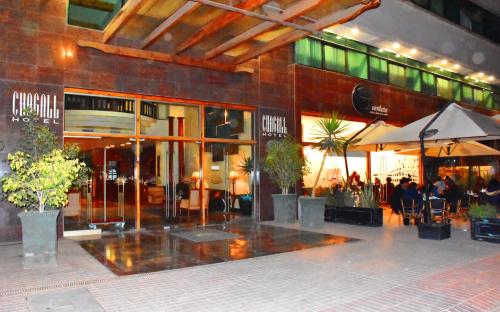 a restaurant with tables and umbrellas in front of a building at Hotel Chagall in Copiapó