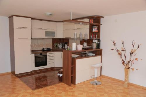 a kitchen with white cabinets and a vase in a room at Vila Viktori in Pirot
