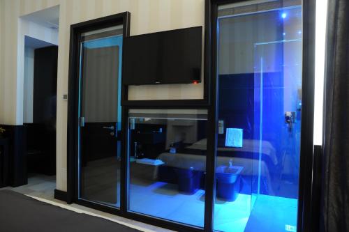 a room with a glass door with a bed in it at Muro Torto suite - Struttura sanificata giornalmente con ozono e prodotti specifici conformi al Decalogo del Ministero Salute - Personale sottoposto a test sierologico periodicamente in Foggia