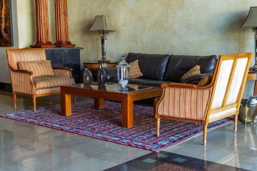 a living room with a couch and a table and two chairs at Hotel Chagall in Copiapó