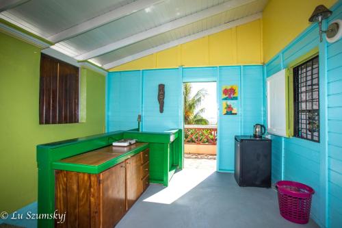 a kitchen with blue and green walls at Veranda View Guesthouse in Calibishie