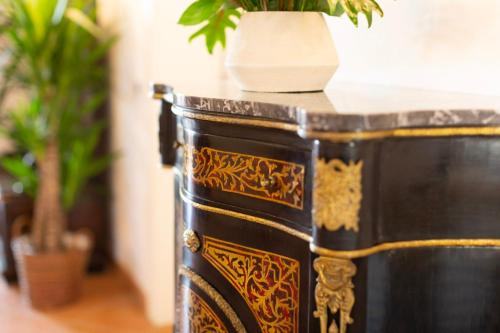 a black and gold table with a potted plant on it at Princess Art Hotel in Ferrara