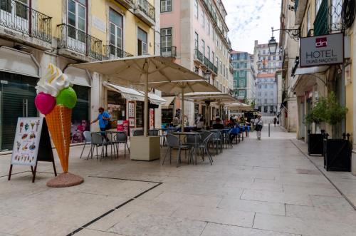 an empty street with tables and chairs and an ice cream cone at Hotel Duas Nações in Lisbon