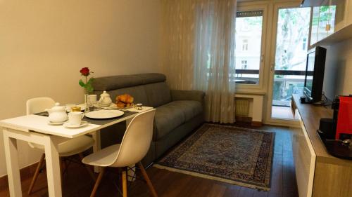 salon ze stołem i kanapą w obiekcie Meran/o Centro Guest House w Meranie