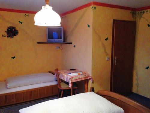 a bedroom with a bed and a tv on the wall at Beim Haxenwirt in Immenstadt im Allgäu