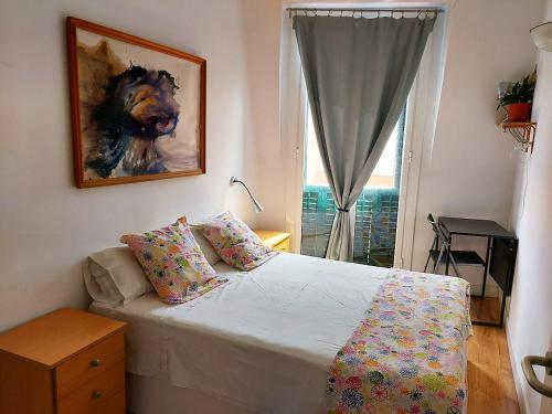 1 dormitorio con 1 cama con una pintura en la pared en Fira Suites, en Barcelona