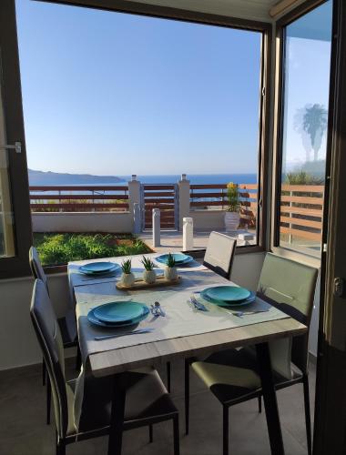 a dining room with a table and chairs and a large window at Wish Sea & Mountain View in Stalos
