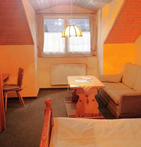 a living room with a table and a couch and a window at Beim Haxenwirt in Immenstadt im Allgäu