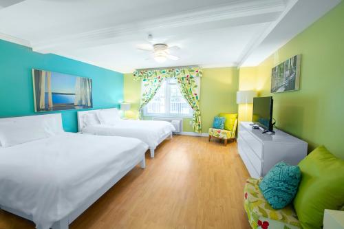 a bedroom with two beds and a tv and a couch at Canalside Inn in Rehoboth Beach