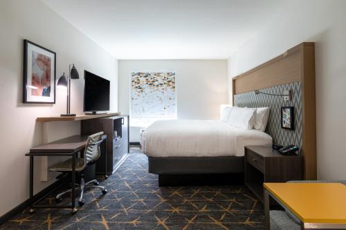 a hotel room with a bed and a desk at Holiday Inn Greenville - Woodruff Road by IHG in Greenville