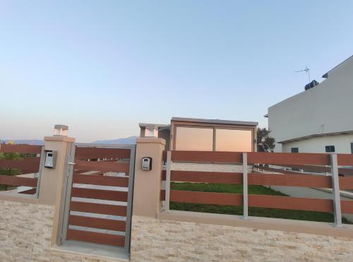 a fence with a gate in front of a house at Wish Sea & Mountain View in Stalos