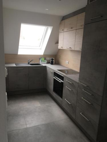 a kitchen with a sink oven and a window at Zeitfrei-Apartments in Kirchheim unter Teck