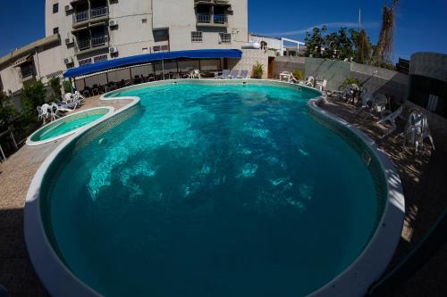 a large swimming pool in front of a building at Hotel Renacer in Santo Domingo