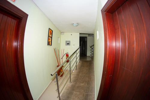 a long hallway with a red door and stairs at Hotel Renacer in Santo Domingo