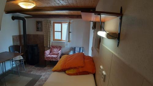 Habitación pequeña con cama y silla en Pavlov24 - Zahradní domečky, en Pavlov