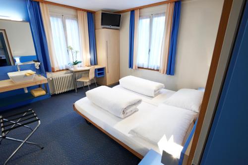 um quarto de hotel com duas camas e uma secretária em Hotel Kreuz em Malters