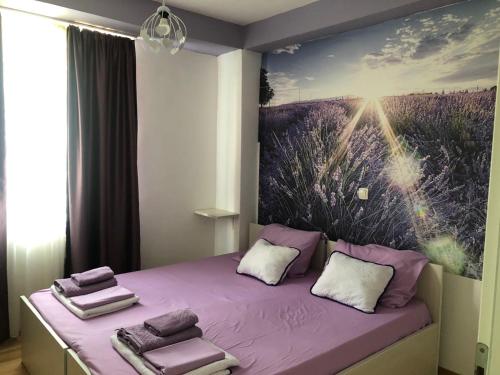 Dormitorio con cama morada y pintura en la pared en City Apartment, en Ohrid