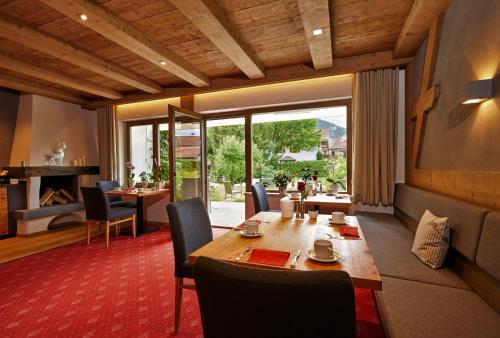 ein Esszimmer mit einem Holztisch und Stühlen in der Unterkunft Hotel Garni Zugspitz in Farchant