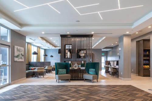 a lobby with a waiting area with chairs and tables at Holiday Inn Greenville - Woodruff Road by IHG in Greenville
