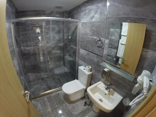 a bathroom with a toilet and a shower and a sink at Meydan Suites in Istanbul
