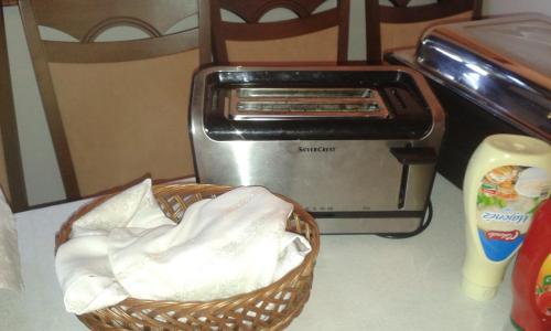 a basket next to a toaster and a toaster oven at Tiffán's Pincészet és Panzió in Villány