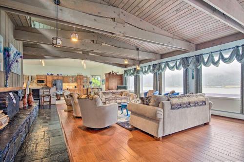 a living room with couches and tables and windows at Waterfront House with Glacial Views - Near Downtown! in Juneau