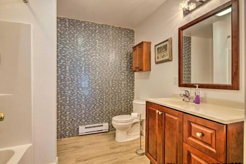 a bathroom with a toilet and a sink and a mirror at Waterfront House with Glacial Views - Near Downtown! in Juneau